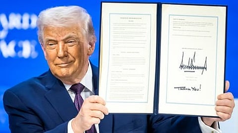 President Donald Trump, center, holds up a signed Board of Peace charter during the Annual Meeting of the World Economic Forum in Davos, Switzerland.