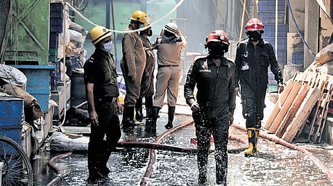 Delhi fire personnel extinguishing the fire that broke out in a factory near MTNL office in Damodar Park, Dilshad Garden Industrial Area.