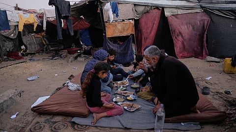 Displaced members of the Al-Zamli family break their fast on the first day of Ramadan inside their tent in Khan Younis, Gaza Strip, Wednesday, Feb. 18, 2026.
