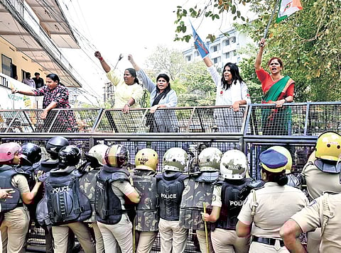 Mahila Congress workers, led by state president MP Jebi Mather, protest on top of the police barricade at the Secretariat, as they march towards Health Minister Veena George’s office
