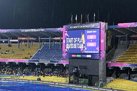 Rain falls as a giant screen displays message for the delayed start in Super 8s match between New Zealand and Pakistan in Colombo
