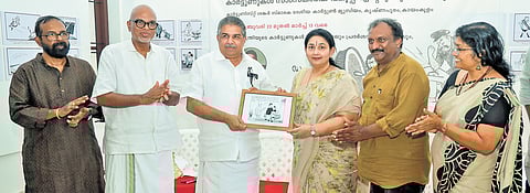 Cultural Affairs Minister Saji Cherian receives a collection of cartoons by P K Manthri from his daughter-in-law Alli Sinilal after inaugurating an exhibition of Manthri’s works. Kerala Cartoon Akademi secretary A Sateesh, Kerala Lalithakala Akademi chairperson Murali Cheeroth, Kerala Cartoon Akademi chairperson Sudheer Nath and Kerala Lalithakala Akademi secretary-in-charge Raji R Pillai are also seen