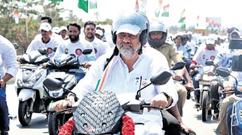 DCM DK Shivakumar rides a bike ahead of the Congress protest against VB-G RAM G at Chikkaballapur on Monday