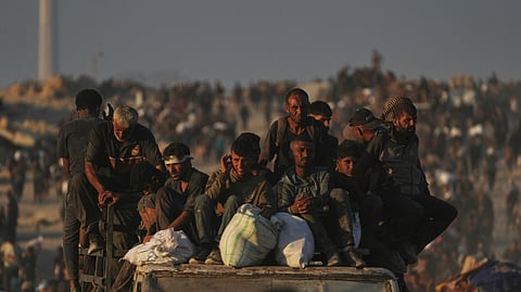 Palestinians carry sacks of flour unloaded from a humanitarian aid convoy that reached Gaza City from the northern Gaza Strip, Sunday, Aug. 24, 2025