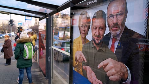 A billboard showing an AI-generated image of Ukrainian President Volodymyr Zelenskyy, center, flanked by European officials is displayed at a bus stop in Budapest, Hungary, Monday, Feb. 23, 2026.