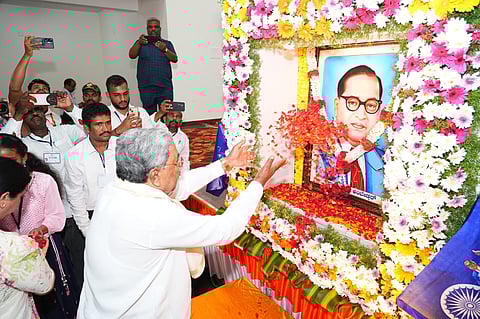 CM Siddaramaiah showers flower petals on the portrait of Dr B R Ambedkar after inaugurating Dr BR Ambedkar Bhavan in Karkala on Wednesday.