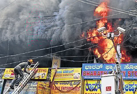 Fire and Emergency Services personnel douse the fire at a 40-year-old commercial complex near Chickpet Metro Station on Wednesday