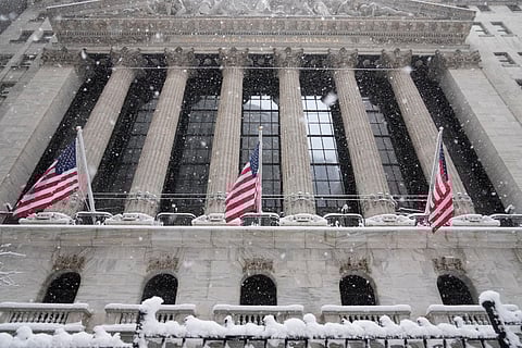 Snow falls outside the New York Stock Exchange, Monday, Feb. 23, 2026, in New York.