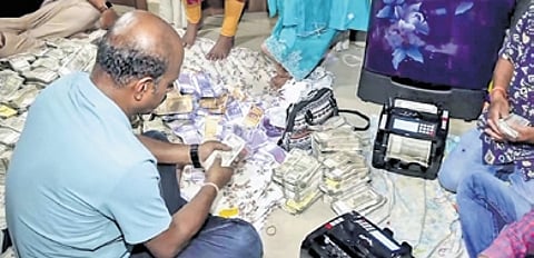 Vigilance officials count seized currency notes & Debabrata Mohanty