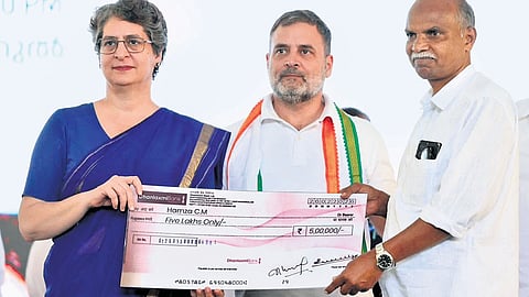 Wayanad MP Priyanka Gandhi and Leader of Opposition in Lok Sabha Rahul Gandhi giving away the cheque of Rs 5 lakh to Hamza C M, a Chooralmala native, who lost his shop in the landslide
