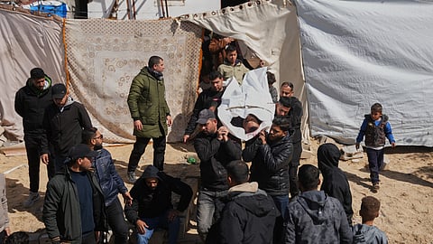Mourners carry the body of the Palestinian policeman, Khaled Al-Zayan, who was killed in an Israeli military strike, during his funeral in Khan Younis, southern Gaza Strip, Friday, Feb. 27, 2026.