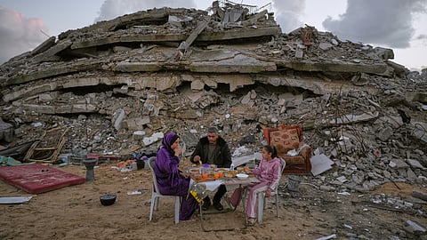 Heba al-Yazji, her husband, Saddam, and their daughter, Maryam, break their fast during the Muslim holy month of Ramadan amid the rubble of destroyed buildings in Gaza City Tuesday, Feb. 24, 2026.