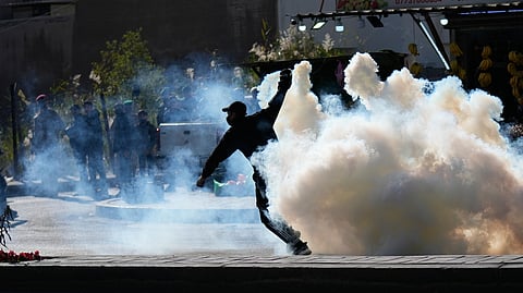 Security forces fire tear gas to disperse a protest against U.S. and Israeli attacks on Iran, at a bridge leading to the fortified Green Zone where the U.S. Embassy is located in Baghdad, Iraq, Sunday, March 1, 2026.
