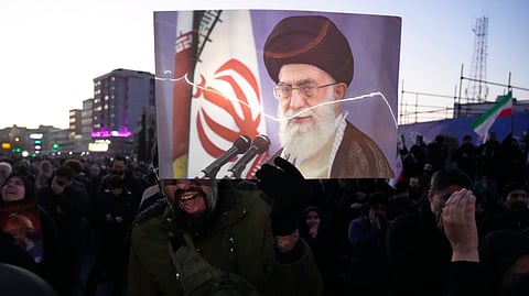 Government supporters mourn in a gathering after state TV officially announced the death of Iranian Supreme Leader Ayatollah Ali Khamenei, shown in the poster, in Tehran, Iran, Sunday, March 1, 2026.