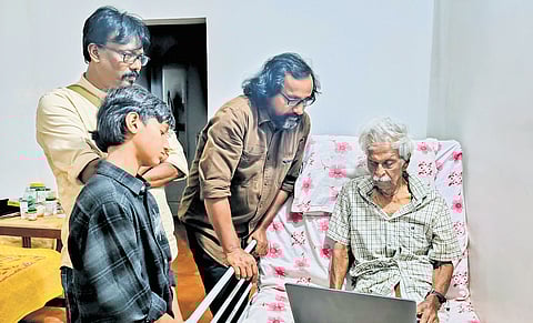 The members of Chithrakar Kerala showing Kanayi Kunhiraman the paintings on him displayed at
the exhibition