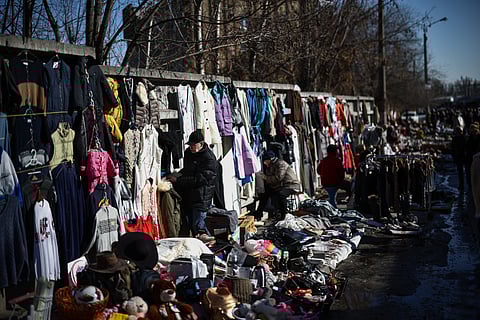 People browse goods for sale at Petrivka Market as temperatures rise above freezing, in Kyiv on March 1, 2026, amid the Russian invasion of Ukraine.