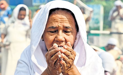 An elderly devotee praying with a handful of rice before offering it into the pot during the Attukal Pongala in Thiruvananthapuram on Tuesday