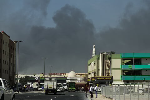 People look at thick smoke rising from the site of a reported Iranian strike in Dubai.
