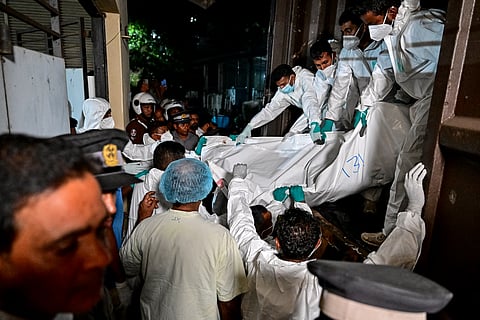 Healthcare workers carry the bodies of Iranian sailors who died in a US torpedo attack on their frigate IRIS Dena off Sri Lanka's southern coast, at the mortuary of the Karapitiya hospital in Galle on March 4, 2026.