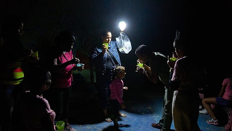 A man gives a girl a spoonful of soup on a street during a blackout in Havana, Wednesday, March 4, 2026.