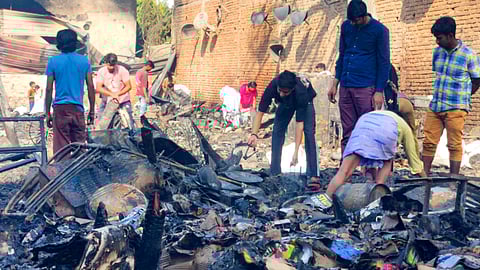People look through charred remains after a massive fire broke out in a cluster of shanties, gutting more than 50 huts, in the Rithala area, New Delhi, Thursday, March 5, 2026.