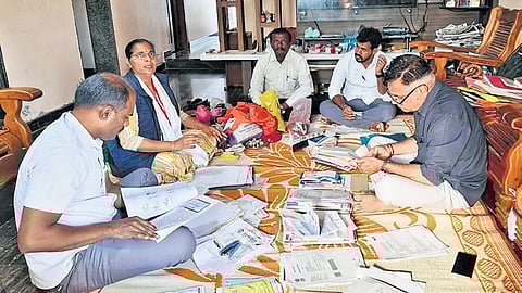 Lokayukta officials examine documents seized from one of the premises they raided on Thursday.
