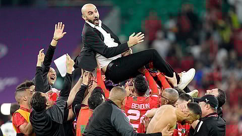 Morocco's head coach Walid Regragui is thrown in the air by players after the World Cup quarterfinal soccer match between Morocco and Portugal, at Al Thumama Stadium in Doha, Qatar, Saturday, Dec. 10, 2022.