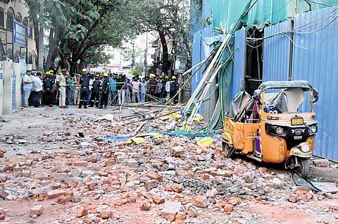 Bricks and other material that fell off the construction site lay strewn about as cops prevent onlookers from entering the site in the city on Thursday