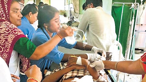A nurse carefully applies a sterile dressing on a student’s wounds in Khammam