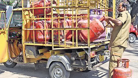 A worker offloads LPG cylinders at a distribution point in Bengaluru.