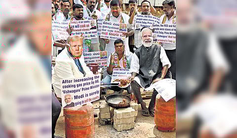 Congress workers protest against PM Narendra Modi and US President Donald Trump for the LPG price hike in Bengaluru on Saturday.