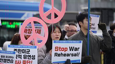 Protesters hold signs to oppose the joint military exercise between the U.S. and South Korea, near the U.S. Embassy in Seoul, South Korea, Monday, March 9, 2026.