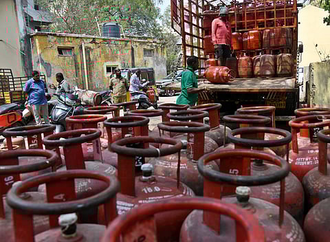 Workers unload LPG cylinders from a delivery truck as concerns grow over a looming shortage of cylinders across Goa