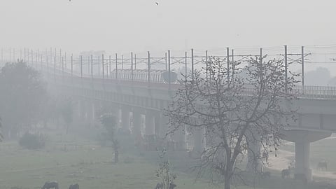 A metro train moves along elevated tracks smoggy conditions in New Delhi, on March 10, 2026.