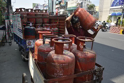 A person working with a gas company distributed cylinders to the consumers who booked in prior, in Vijayawada on Wednesday.