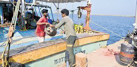 A fisherman hands over an empty cylinder to a delivery personnel at Kasimedu | Martin Louis