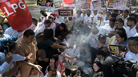 Delhi Pradesh Congress Committee (DPCC) members use a chulha during a protest over the ongoing LPG crisis in the country, in New Delhi on Friday.