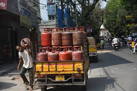 A Worker is seen unloading the LPG Gas cylender from a auto to deliver at a residence in Hyderabad.