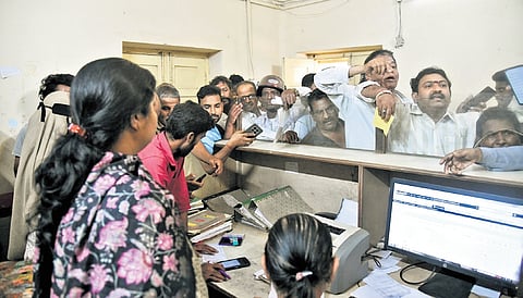 Residents crowd a distribution agency to book and collect LPG refills amid an ongoing shortage, in Hyderabad on Monday