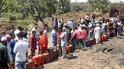People wait in a queue with empty LPG cooking gas cylinders amid a shortage linked to disruptions in LPG supplies due to the ongoing West Asia conflict affecting the global energy supply chain, in Bhopal, Monday, March 16, 2026.