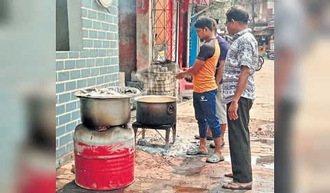 A cook prepares food in a coal stove in Cuttack.