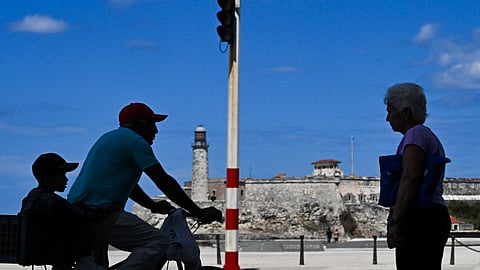 A man rides a bicycle along the coastline of Havana during a blackout on March 16, 2026.