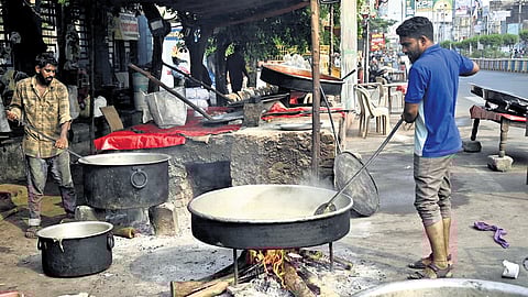Cooks prepare food using firewood at an eatery in Karimnagar on Sunday.