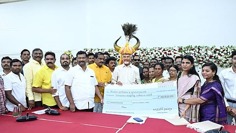 Chief Minister N Chandrababu Naidu hands over a cheque to the displaced families of Polavaram project at his camp office in Undavalli on Wednesday