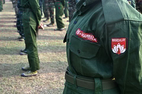 This picture taken during a media event organised by the Myanmar army shows members of the Mandalay People's Defense Forces (MDY-PDF) attending a surrendering ceremony in Mandalay on March 19, 2026.