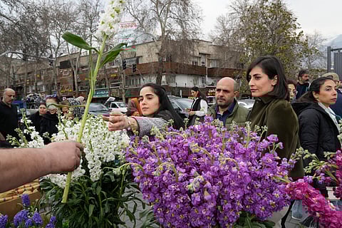 A woman shops for flowers ahead of the Persian New Year, or Nowruz, meaning "New Day," in northern Tehran, Iran, Thursday, March 19, 2026.