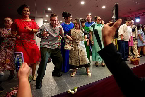 Youngsters dance on the catwalk at the end of the SEEN Anonymous Seamstresses Gala, an event organised by the Down Plus Bucharest, an NGO supporting youngsters with Down Syndrome and other intellectual disabilities, in Bucharest