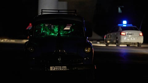 People are seen waiting in a car in the dark during a blackout in Havana, Cuba, Saturday, March 21, 2026.