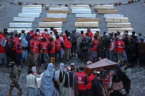 Coffins containing the remains of victims of a Monday airstrike on a drug rehabilitation hospital are laid out before burial in Kabul, Afghanistan, Wednesday, March 18, 2026.