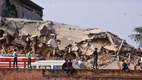 People gather as a rescue operation is underway after a cold storage building collapsed, at Phaphamau, in Prayagraj district, Uttar Pradesh, Monday, March 23, 2026.